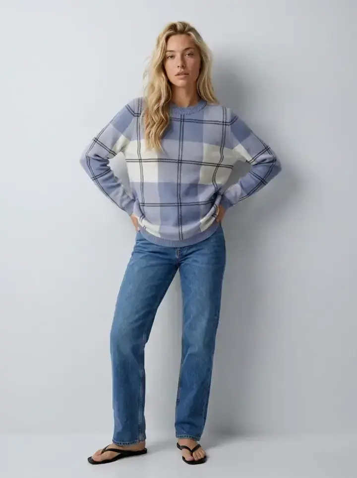 First frame of a Kling 3 Pro clip of the saved AI model in a cropped white jacket on the grey studio set, generated inside Uwear from an approved photo