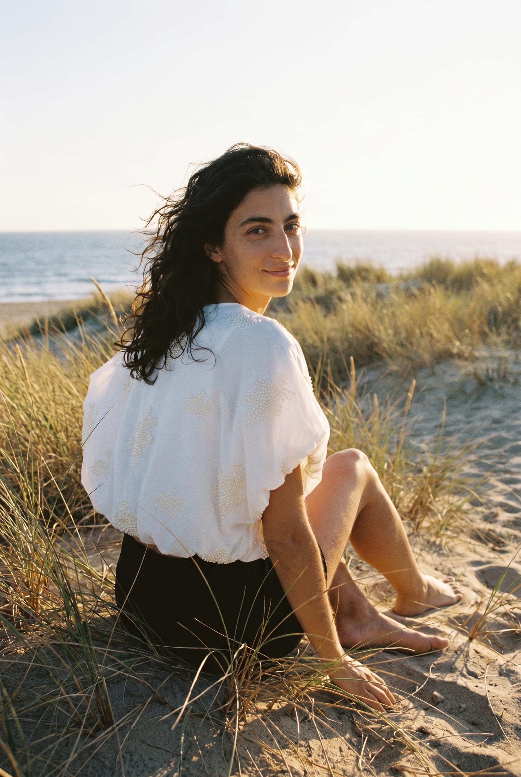 Coastal direction: puff-sleeve top seated on a dune
