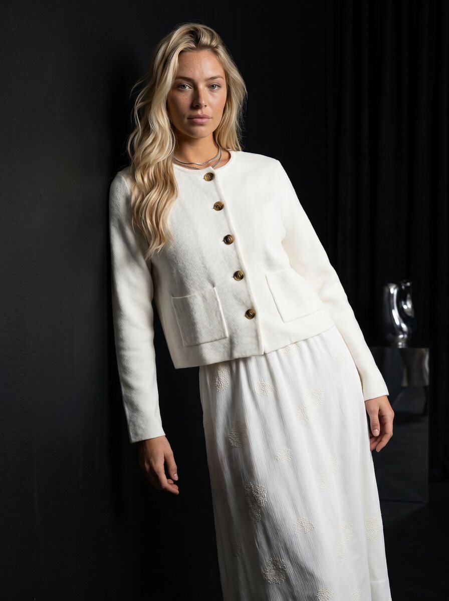 Generated noir studio shot of Oli in the ivory jacket and skirt