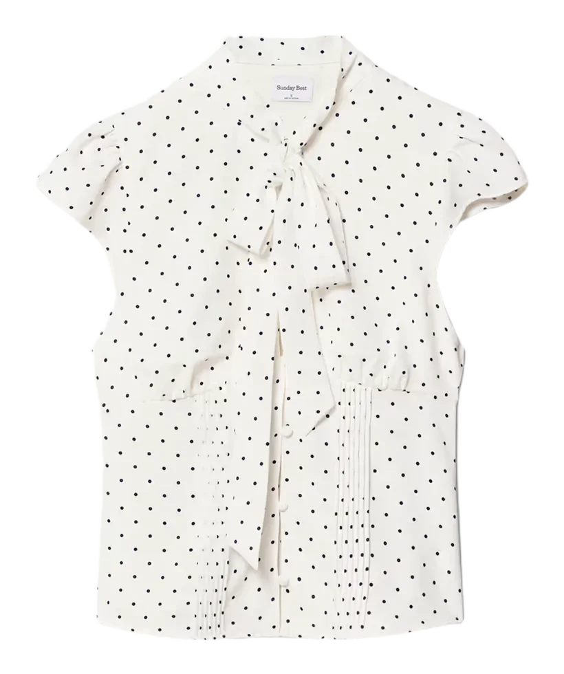 Product photo of a white polka-dot tie-neck blouse with cap sleeves and pintuck pleats, the reference uploaded to Uwear